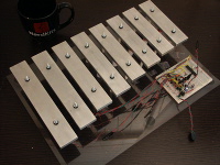 The NerdKits Robotic Xylophone has 8 individually tuned aluminum bars making up a C-major scale. Solenoids, controlled by a microcontroller, strike the bottom of each bar and make music.