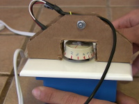 The servo is coupled to the dimmer knob by gluing the servo arm to the knob.
