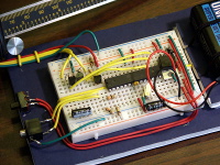 The breadboard, battery, power switch, and audio port were mounted on a piece of foamboard. The low-bias-current power supply for the calipers is also visible just to the right of the two transistors performing the level shifting.